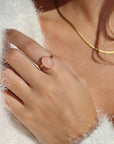 Model is wearing our rose quartz entwined ring in 14k gold fill, this ring features a rose quartz stone on a textured thick band. This band has a "entwined" textured look. 