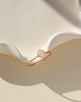 14k gold fill ring featuring a 5mm rose quartz gemstone set in a 14k gold fill thin band. The ring is displayed on a cream backdrop. 