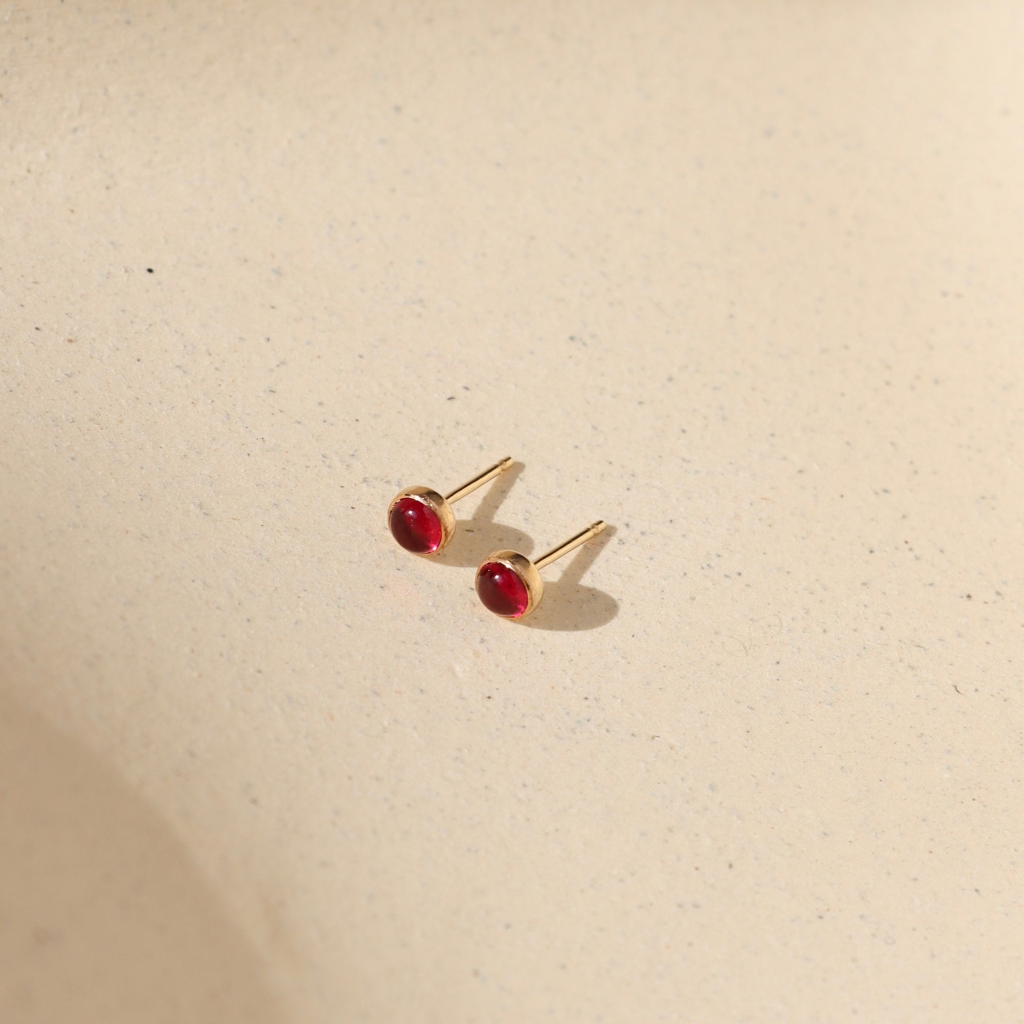 14k gold fill bezel earring setting with ruby stone in the sunlight