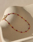 ruby enamel chain link with 14k gold fill chain on a wavy plate in the sunlight