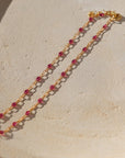 14k gold fill chain with ruby transparent gemstones on a light dish