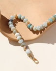 A fully beaded 14k gold fill anklet filled with amazonite gemstones and shell spacer beads. The anklet is displayed on a orange dish. 