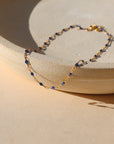 14k gold fill chain with sapphire gemstones on a light dish