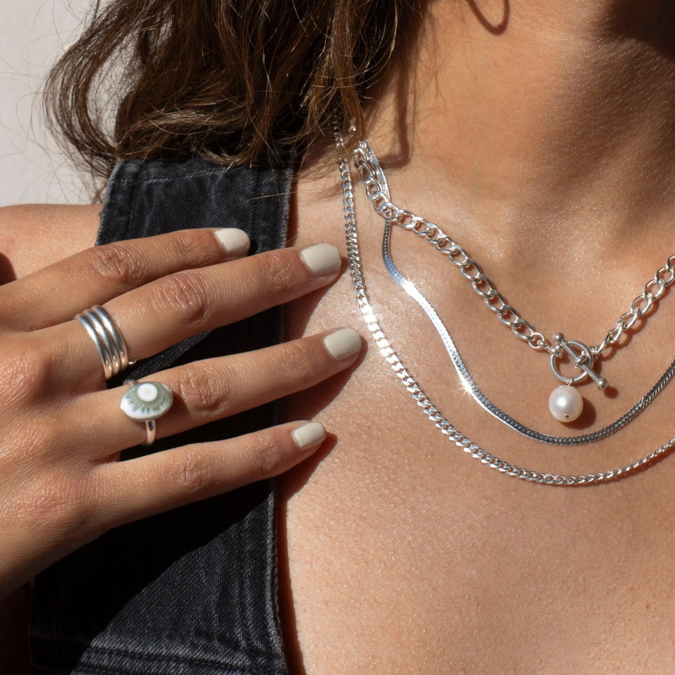Model wearing sterling silver jewelry with a pearl and an oval ocean jasper stone