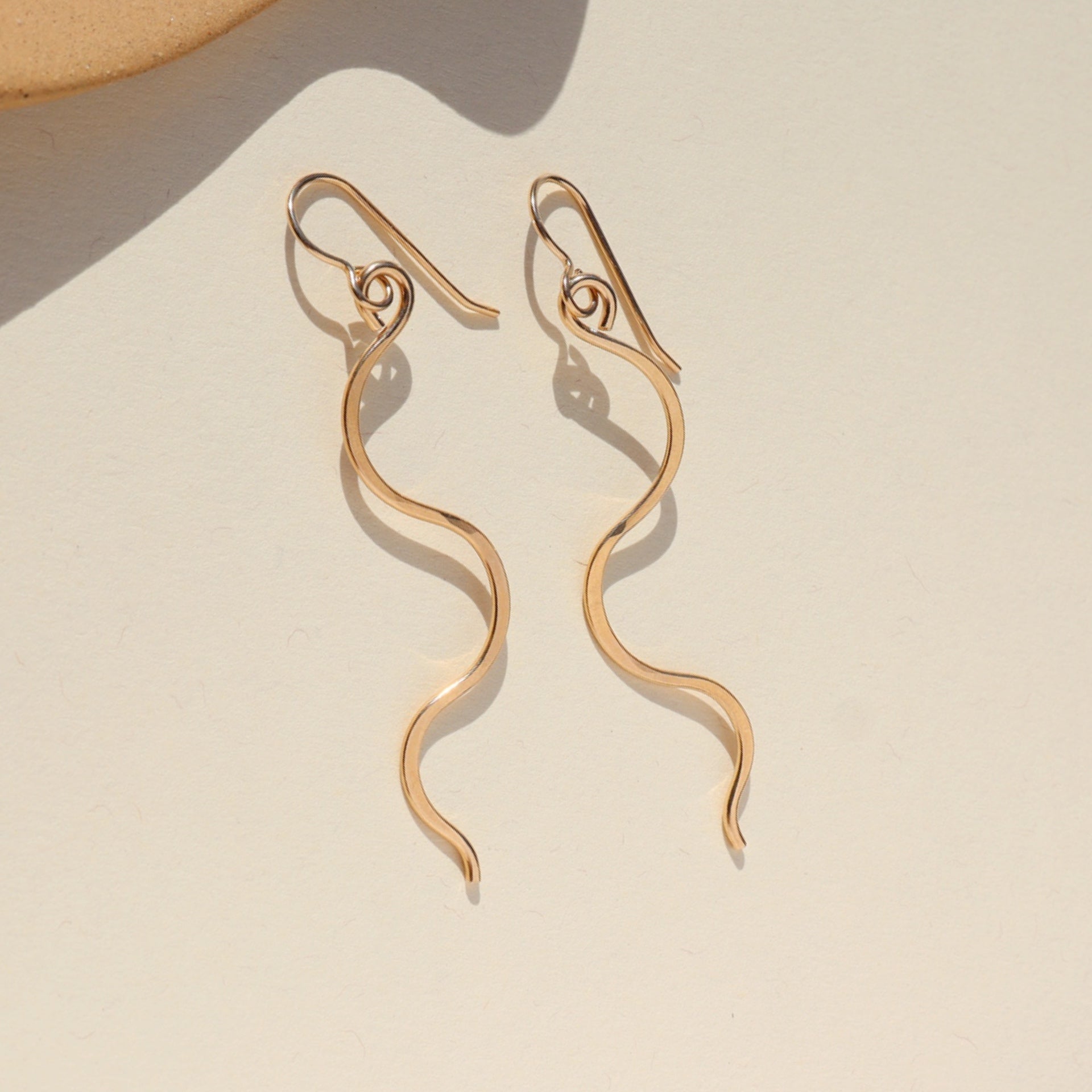 14k gold fill swivel earrings on french ear hooks on a light background