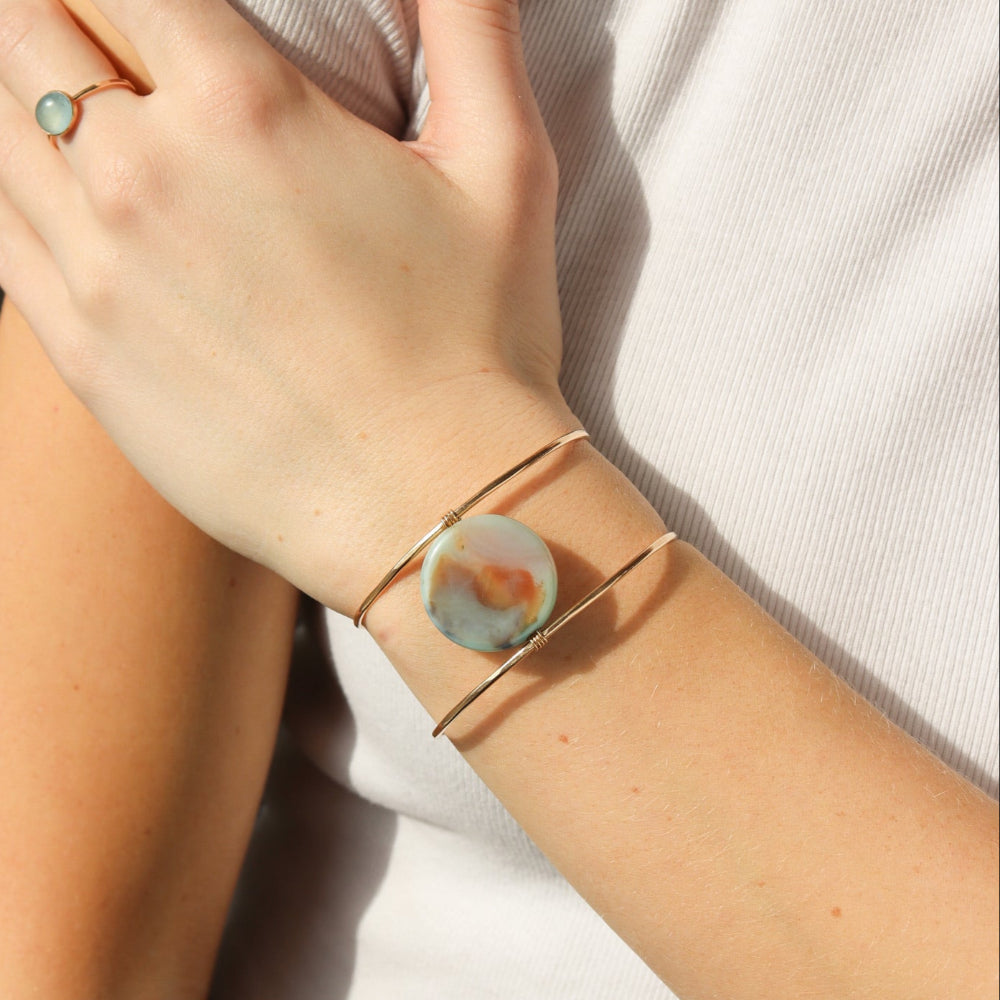 Model wearing the siren cuff. It features a Terra Agate Gemstone wire wrapped to a 14k gold fill wide cuff. 