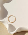 Simple spiral gold band, displayed on a white dish. 