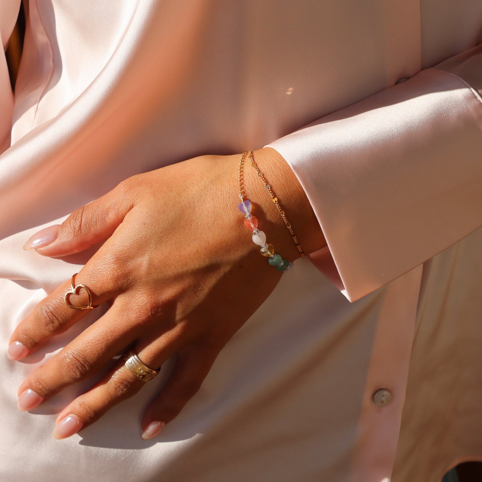 model wearing multicolored heart bead bracelet with 14k gold fill chain - paired with 14k gold fill bracelet and rings