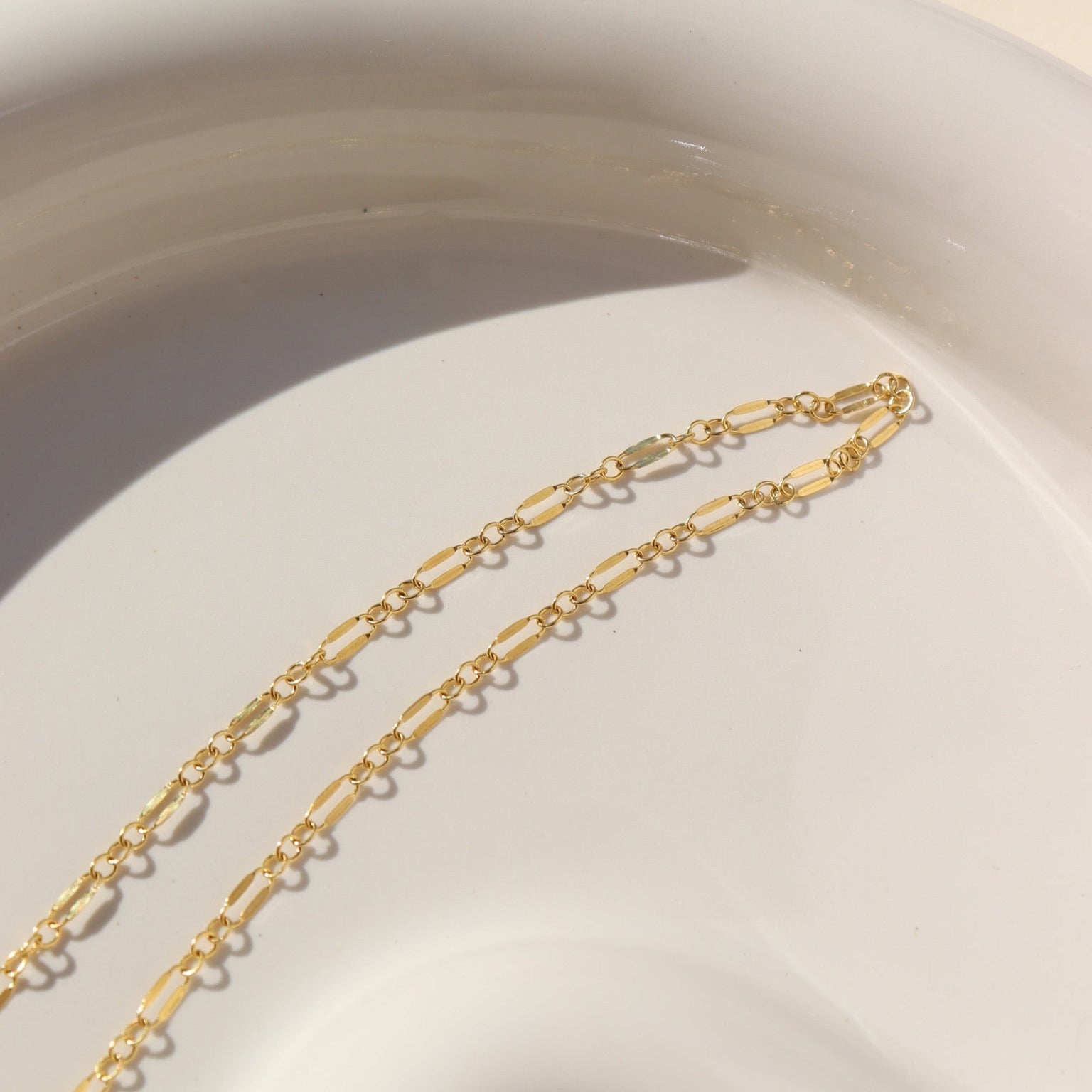 14k gold fill double bar chain bracelet on a light dish