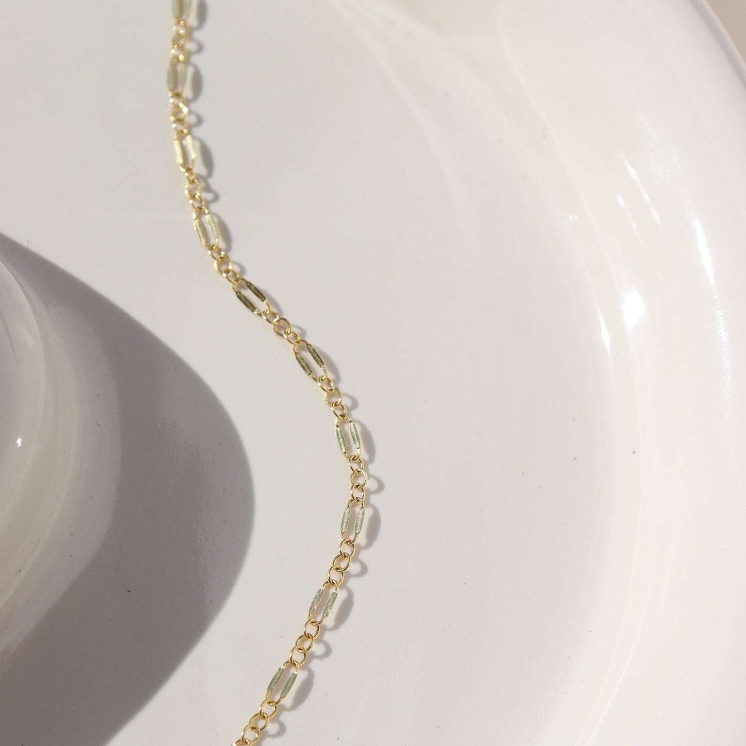 14k gold fill double bar chain bracelet on a light dish
