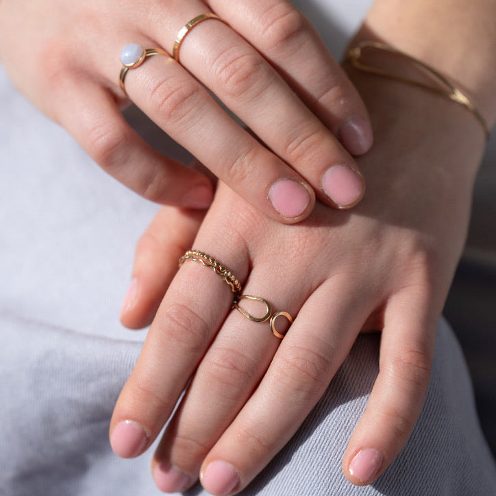 model wearing 14k gold fill ring with blue lace agate stone paired with other 14k gold fill rings