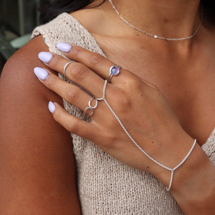 model wearing sterling silver hand chain with other sterling silver jewelry
