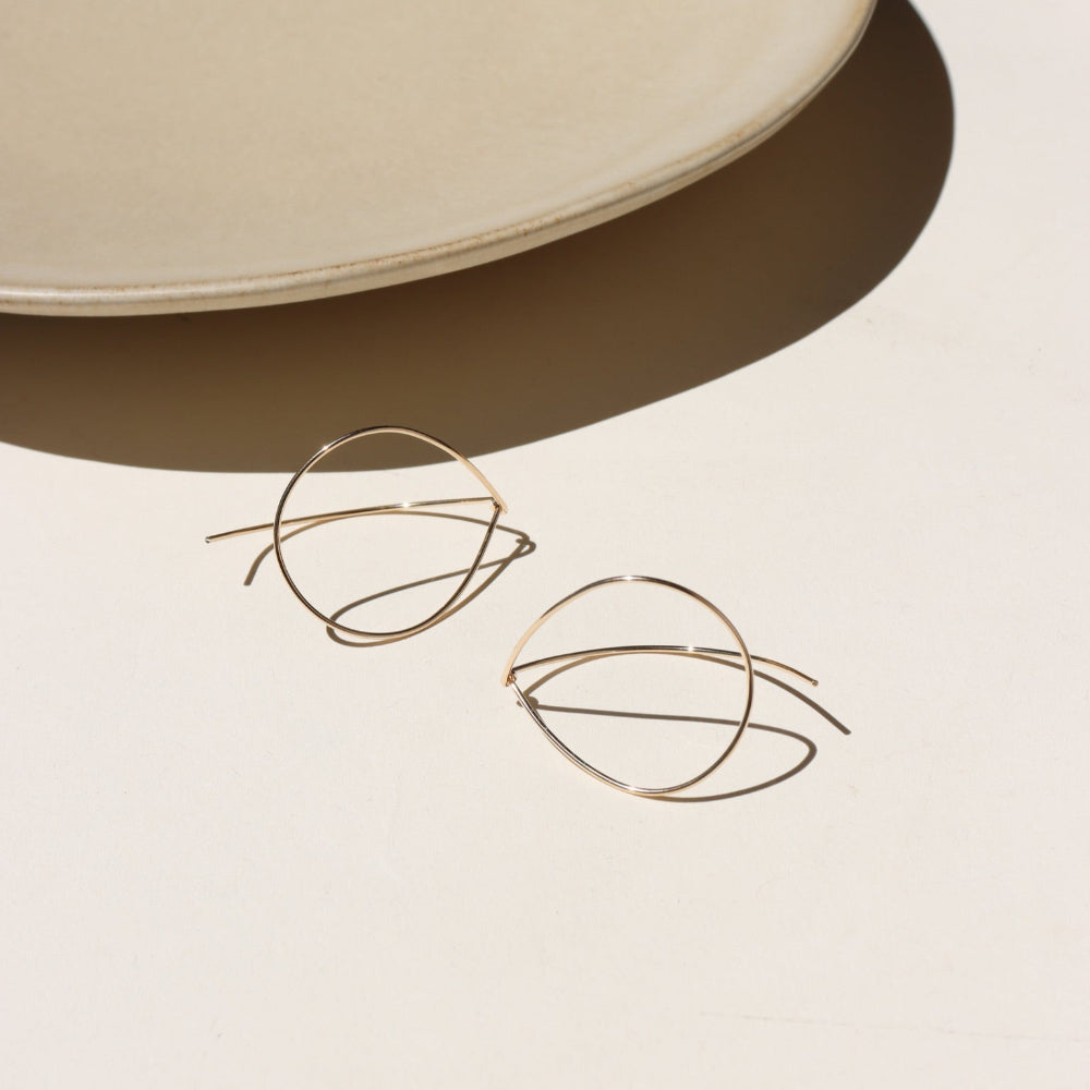 14k gold fill threader earrings on a light surface with a neutral background