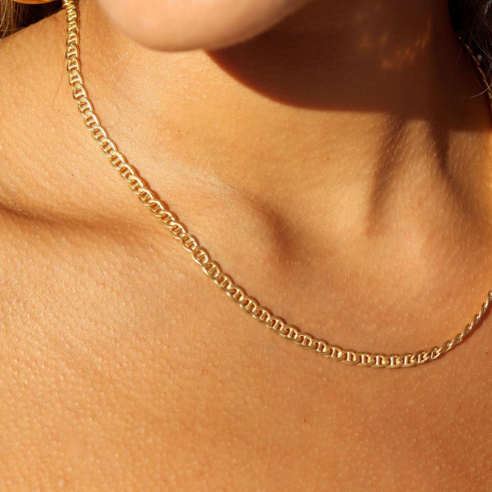 The Marina Chain by Token Jewelry, a modern classic with interlocking oval-shaped links, photographed on a model