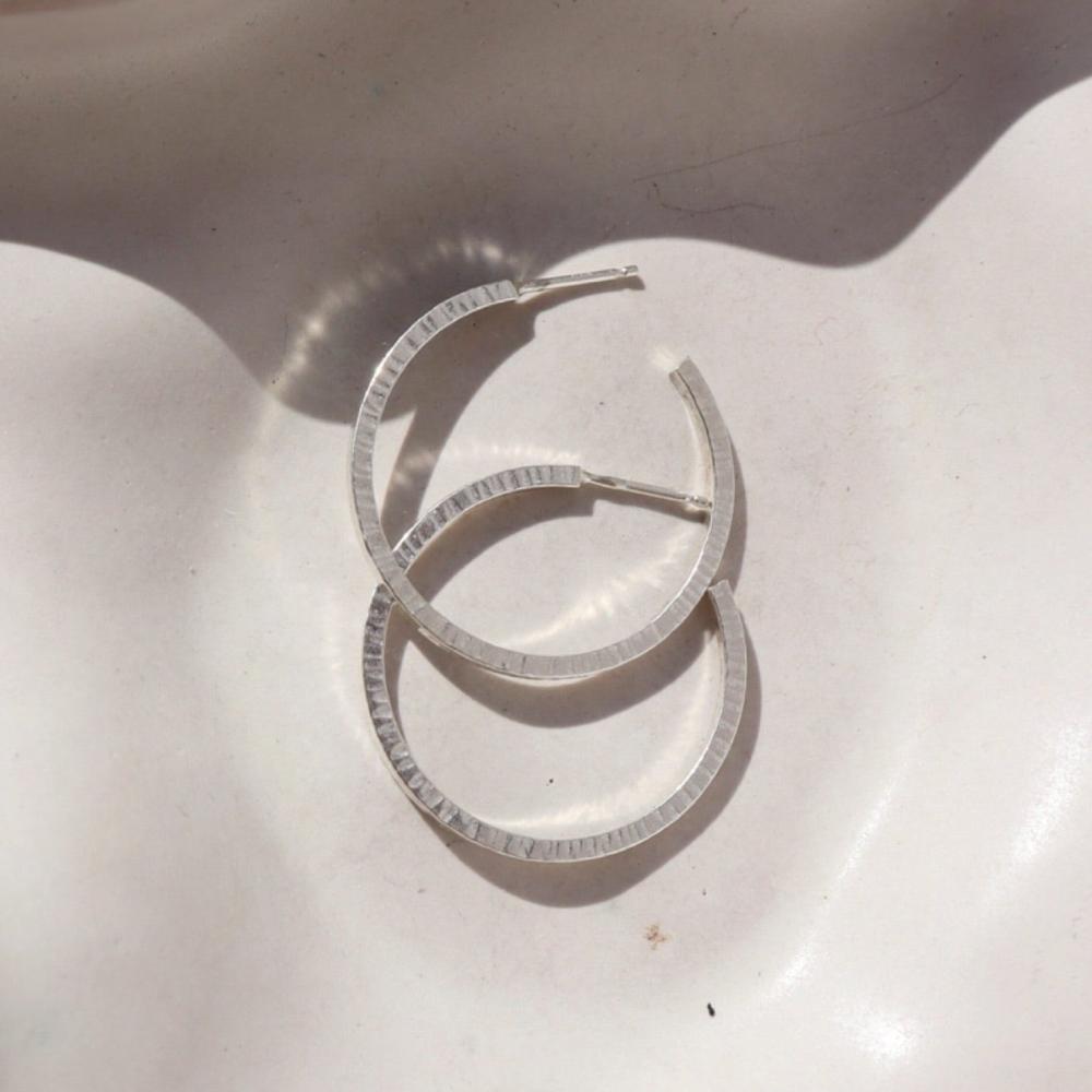Token jewelry petite maeve hoops in sterling silver on a white dish