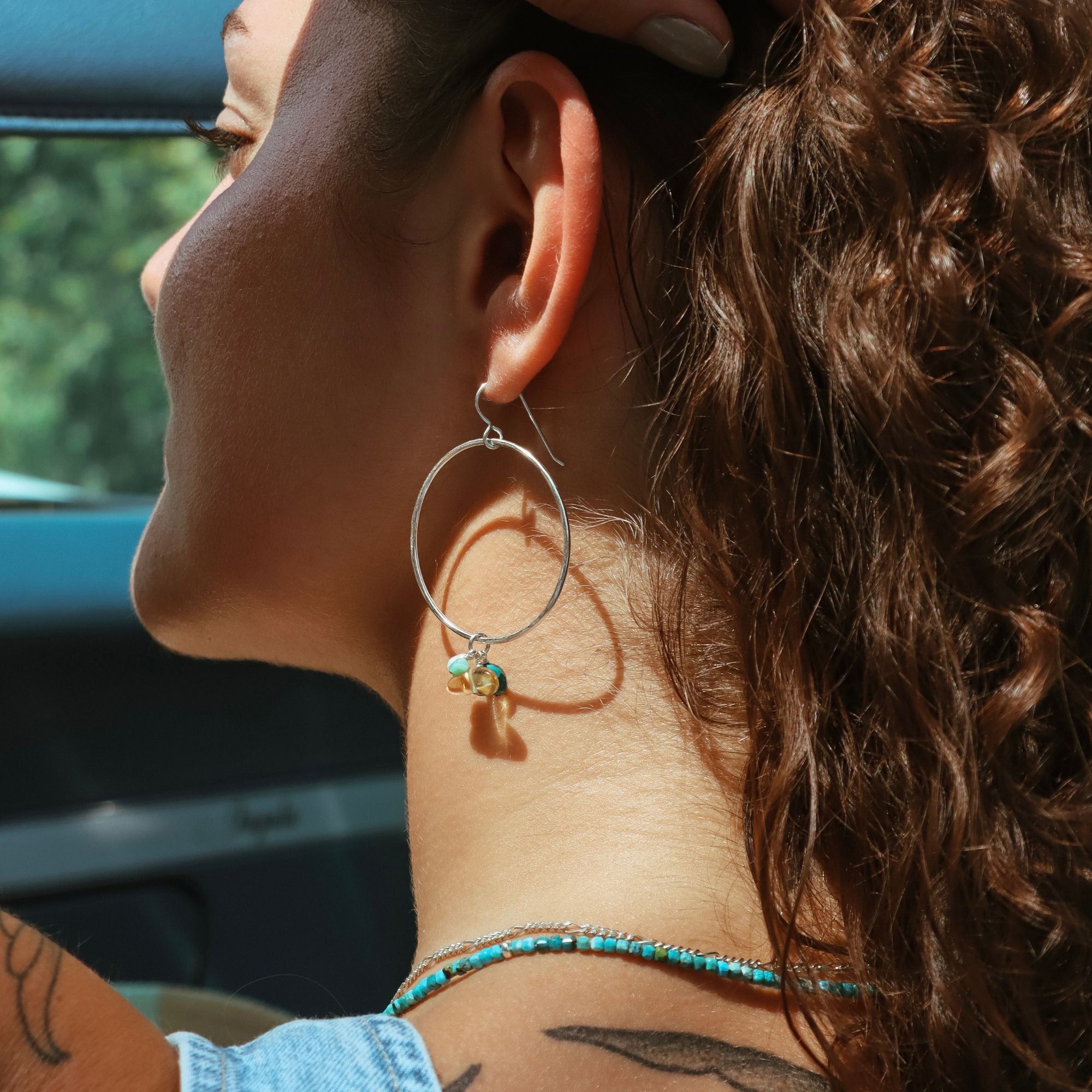 model wearing sterling silver hoops with gemstones and beaded turquoise necklace