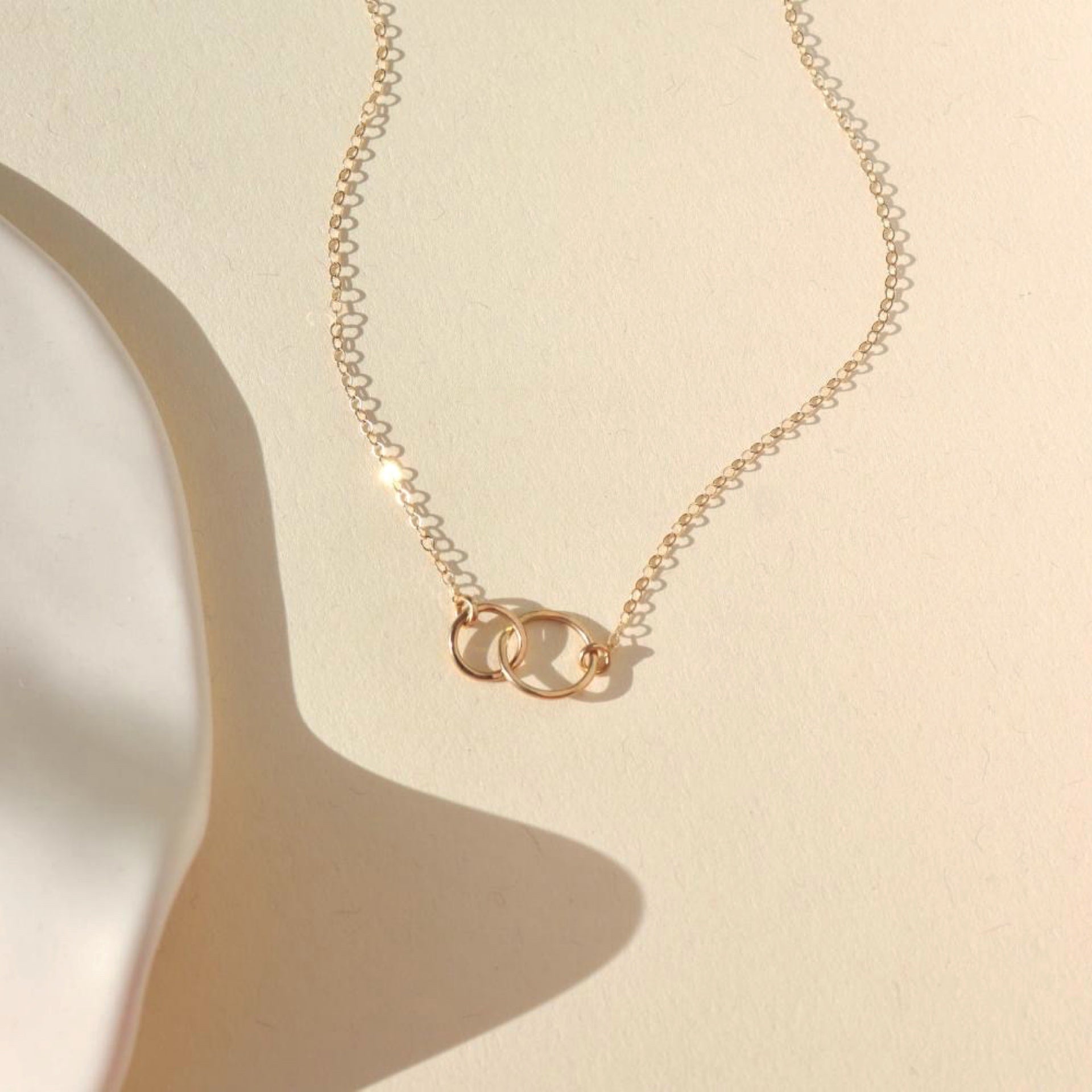 14k solid gold linked hammered circle pendent necklace on a dainty chain in the sunlight