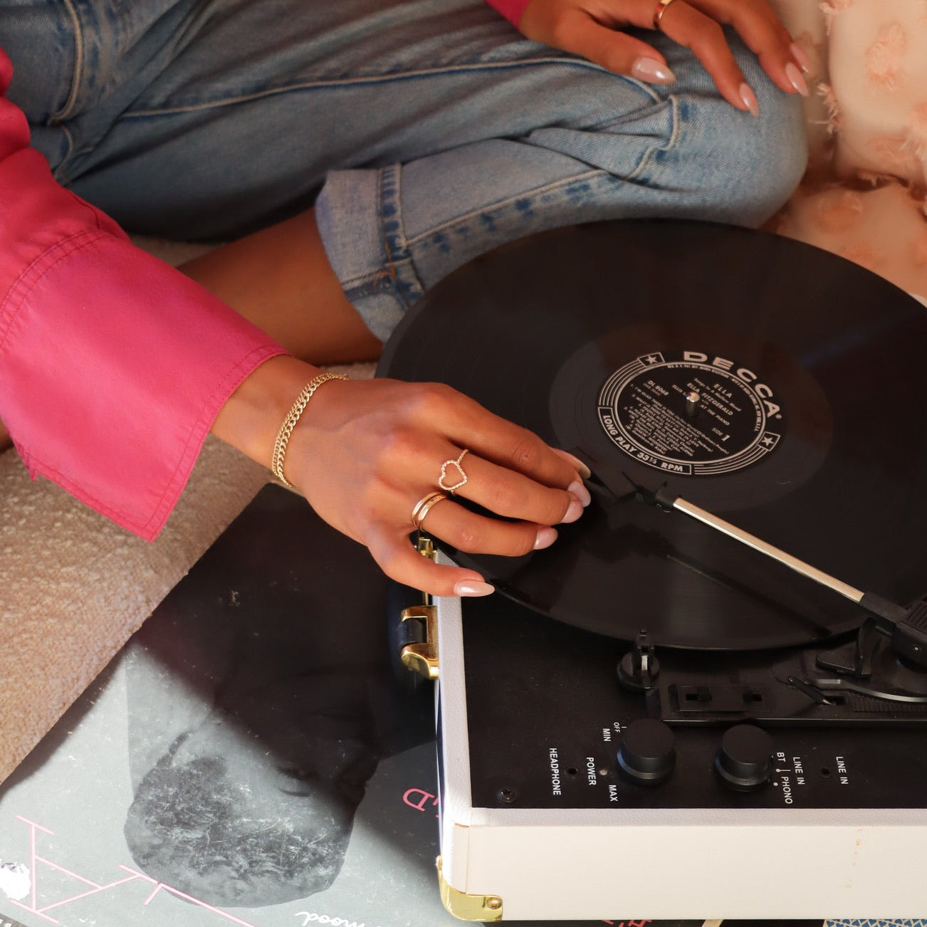 model wearing 14k gold fill heart shaped spiral ring with two 14k gold fill rings - lifestyle shot - record player