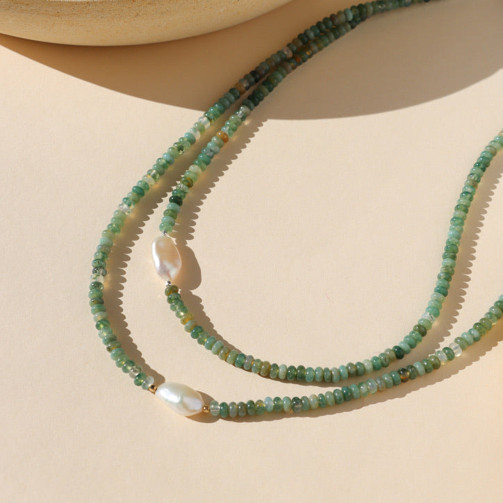 beaded necklace featuring moss agage and pearl beads on a light background