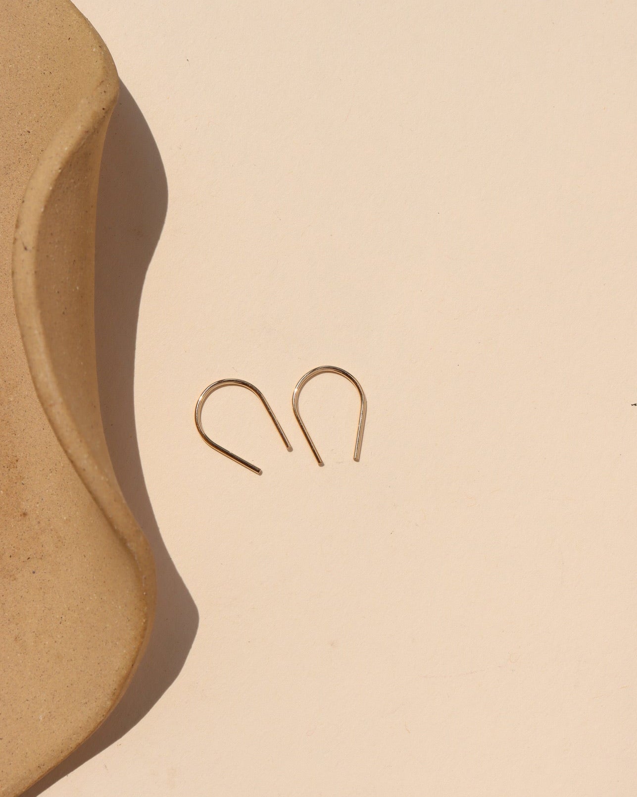 14k gold fill small horseshoes in sunlight