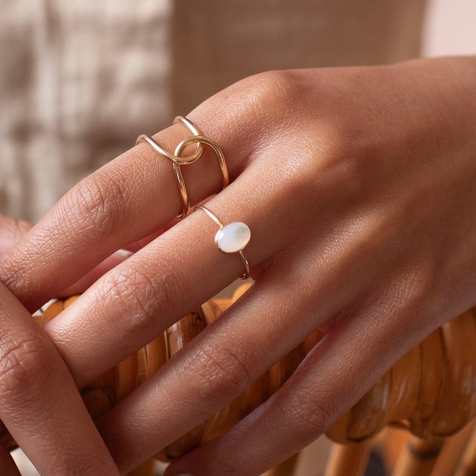 mother of pearl stone set in a bezel on a 14k gold fill skinny ring band, photographed on a model&#39;s hand