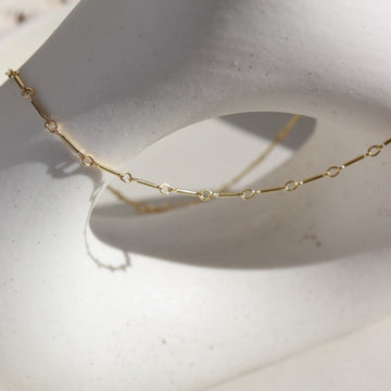 14k gold fill Dot + Dash Choker placed on a white pot - Necklace - Token Jewelry - Eau Claire Jewelry Store - Local Jewelry - Jewelry Gift - Women's Fashion - Handmade jewelry - Sterling Silver Jewelry - Gold filled jewelry - Jewelry store near me