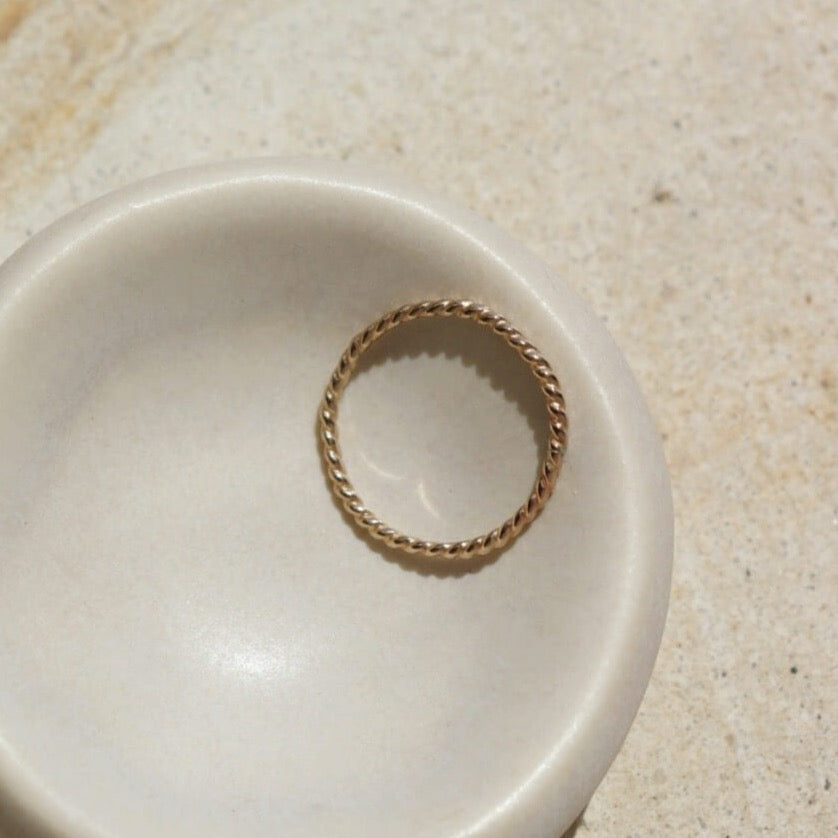 14k gold fill Spiral Ring laid in a white ring dish. This ring features a simple spiral band making it perfect for stacking.