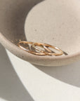 14k gold fill hammered standing ring is placed on top of each other. The rings then are placed on a gray plate laying in the sunlight. These rings are lightly hammered gold stacking ring, handmade by Token Jewelry in Eau Claire, Wisconsin