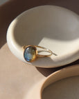 14k gold fill Labradorite Ring placed on a white dish in the sunlight. 