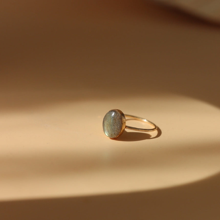 14k gold fill Labradorite Ring place on a tan plate in the sunlight. - Token Jewelry