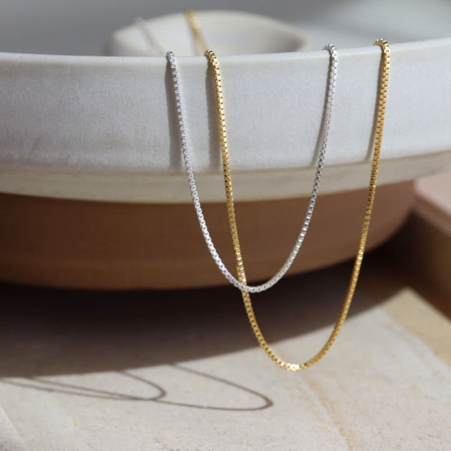 925 Sterling silver and 14k gold fill Necklace laid on a cream plate in the sunlight.