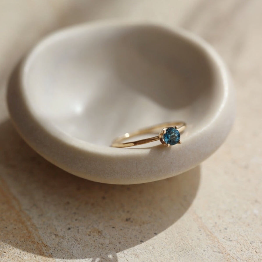 A timeless soft London blue topaz sits on a 14k gold solitaire band, December birthstone, soft blue hue, gift, handmade in eau claire, wisconsin, handmade jewelry, heirloom collection, everyday solid gold, solitaire ring, blue gemstone ring