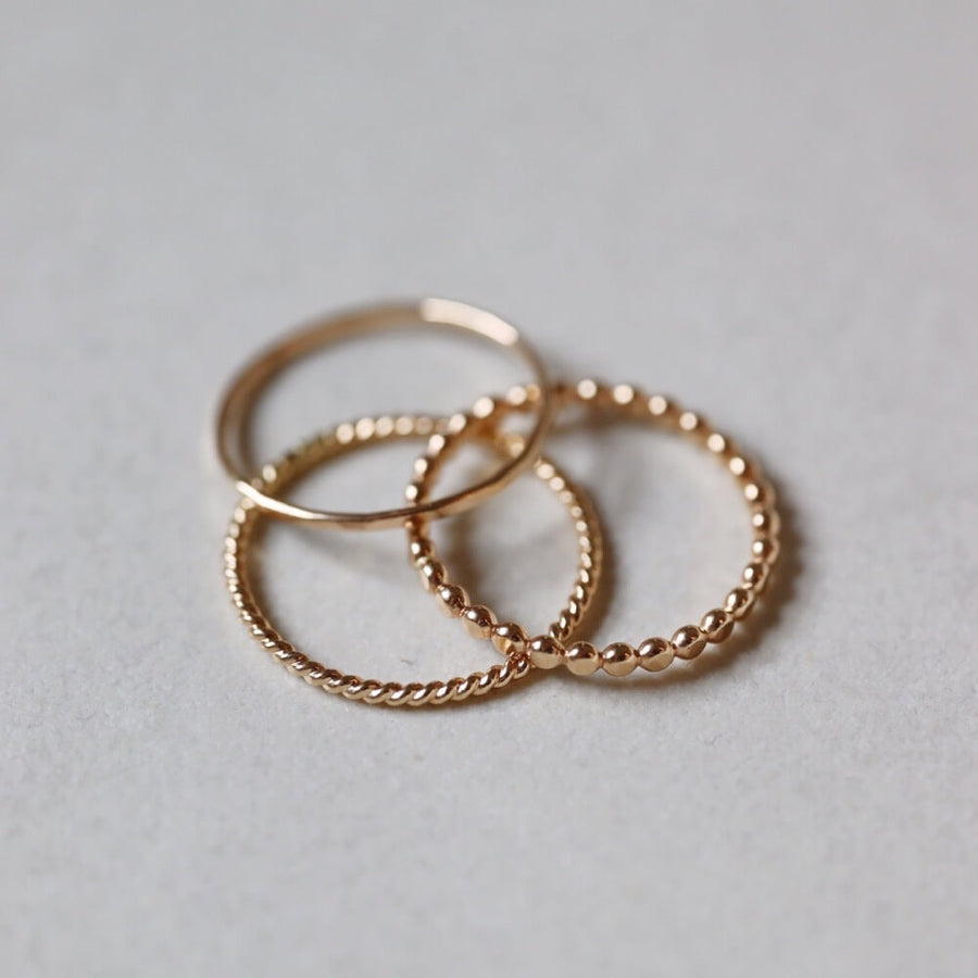 14k gold fill SoHo Ring Set placed on a white plate. This Ring set highlights each one of our go to stacking rings including the stacking ring, spiral ring, and sequins ring. These rings are made to live in made to wear everyday. 