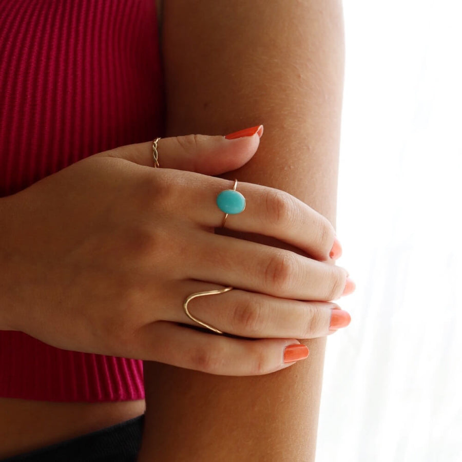 Model wearing 14k gold fill Splash Ring Laid on a tan paper in the sunlight. this ring features the ammonite gemstone. - Token Jewelry