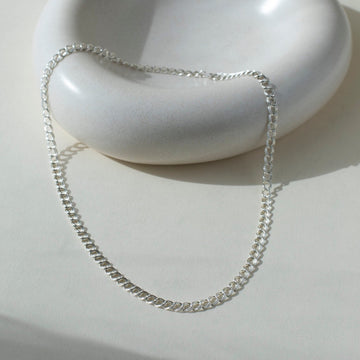 925 Sterling Silver Double link necklace laid on top of a white clay plate. Jewelry is handmade in Eau Claire Wisconsin. Hypoallergenic jewelry made to live in.