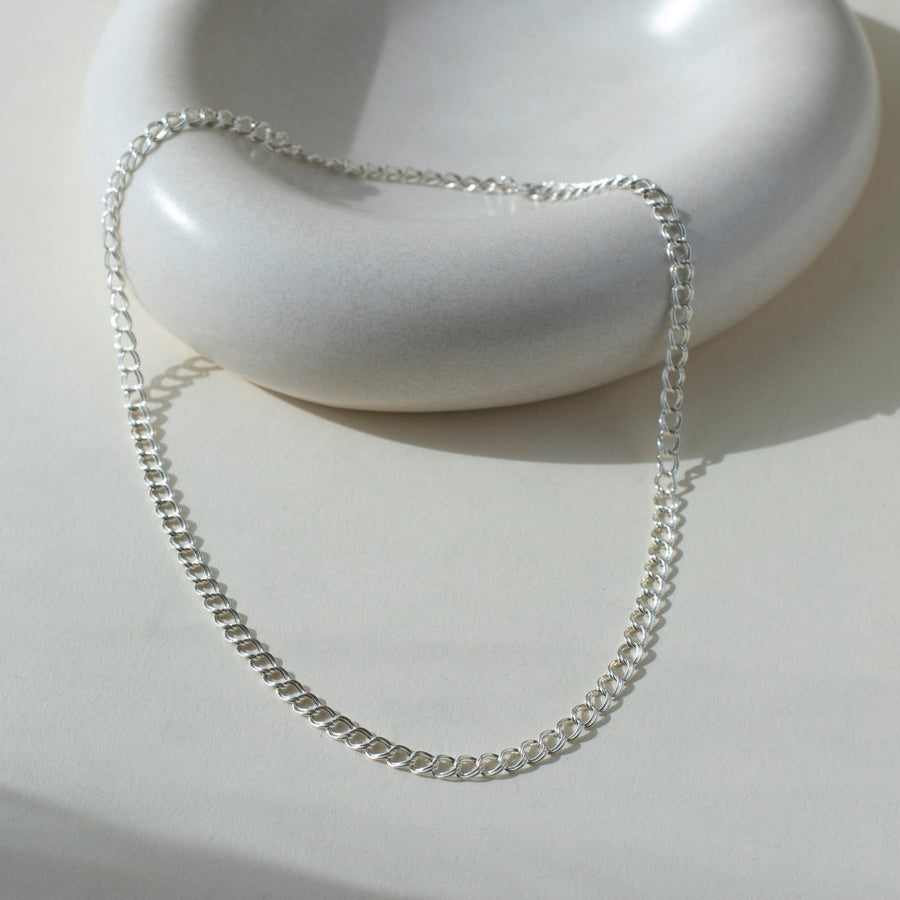 925 Sterling Silver Double link necklace laid on top of a white clay plate. Jewelry is handmade in Eau Claire Wisconsin. Hypoallergenic jewelry made to live in.