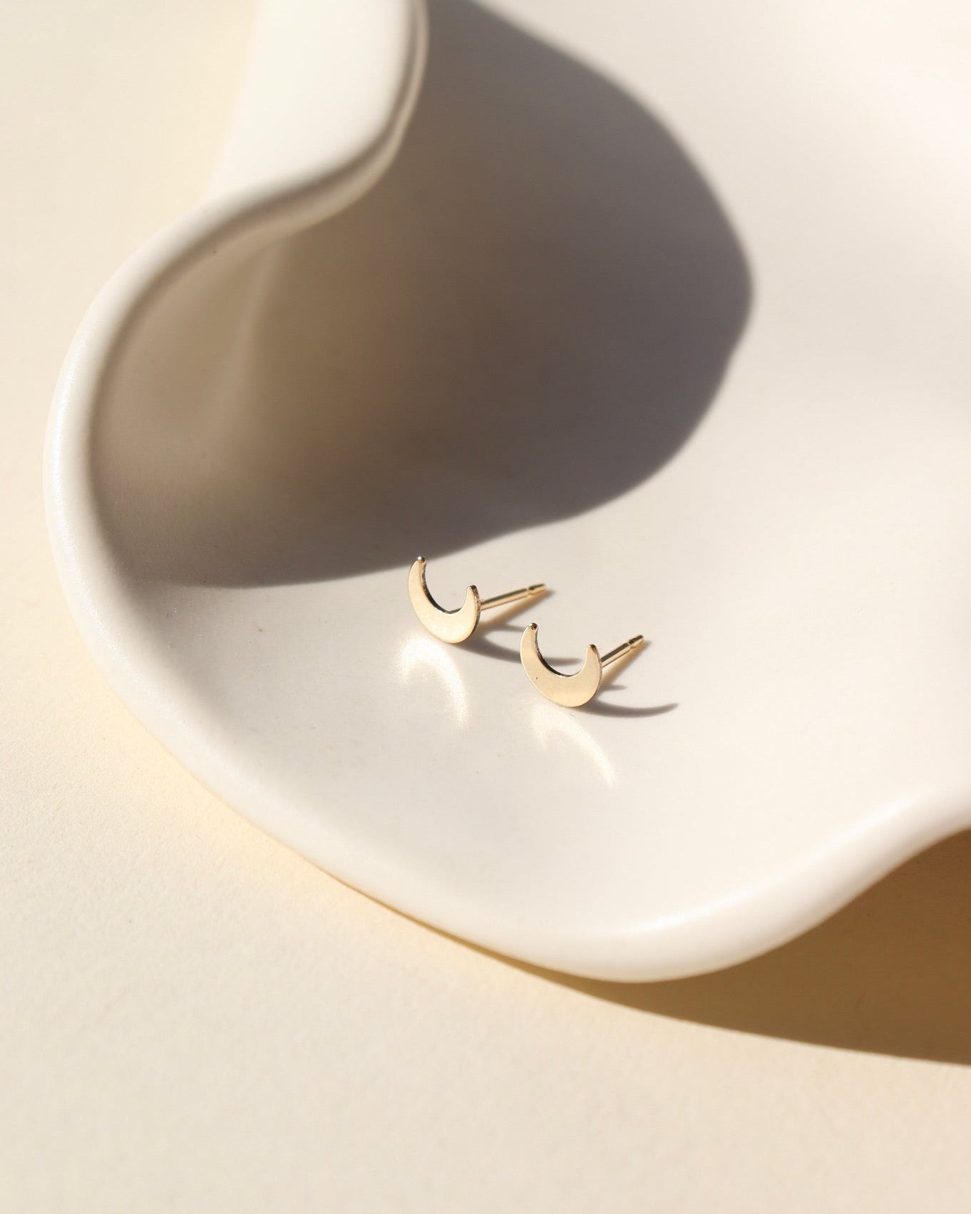 tiny moon studs in 14k gold fill by token jewelry